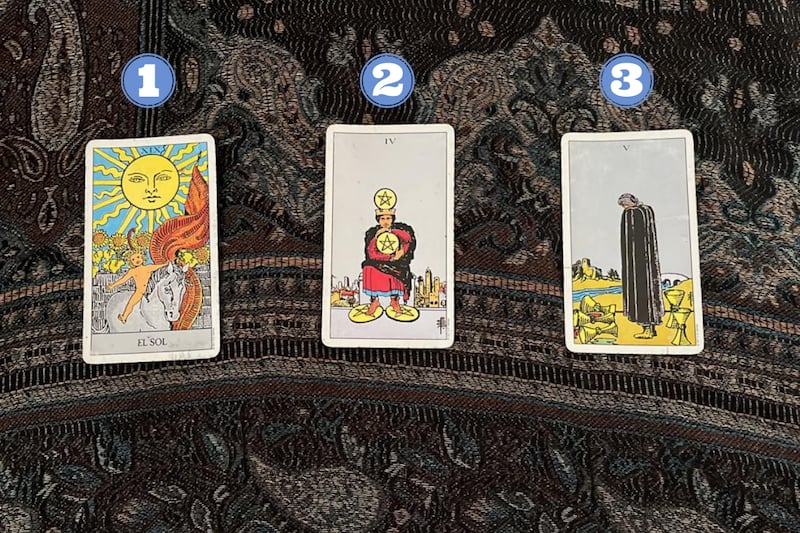 Tres cartas del Tarot reveladas sobre una tela.