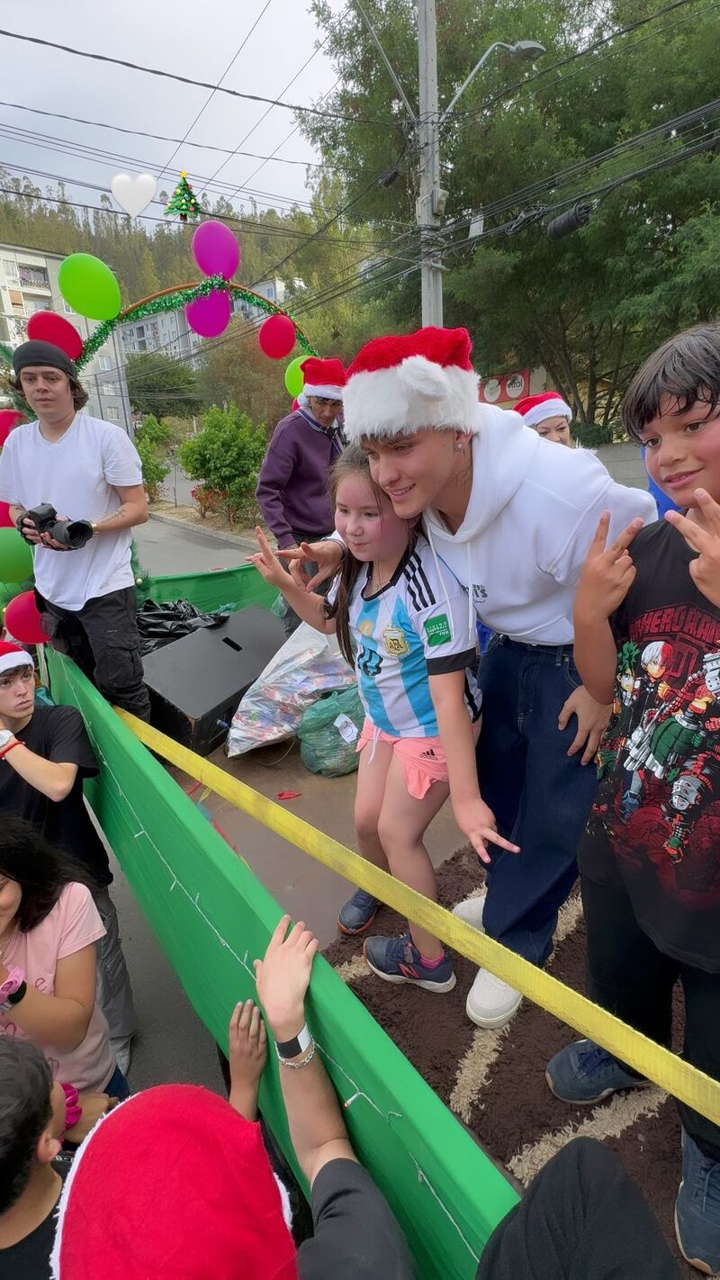 Hans Valdés tomándose una foto con dos niños de Constitución